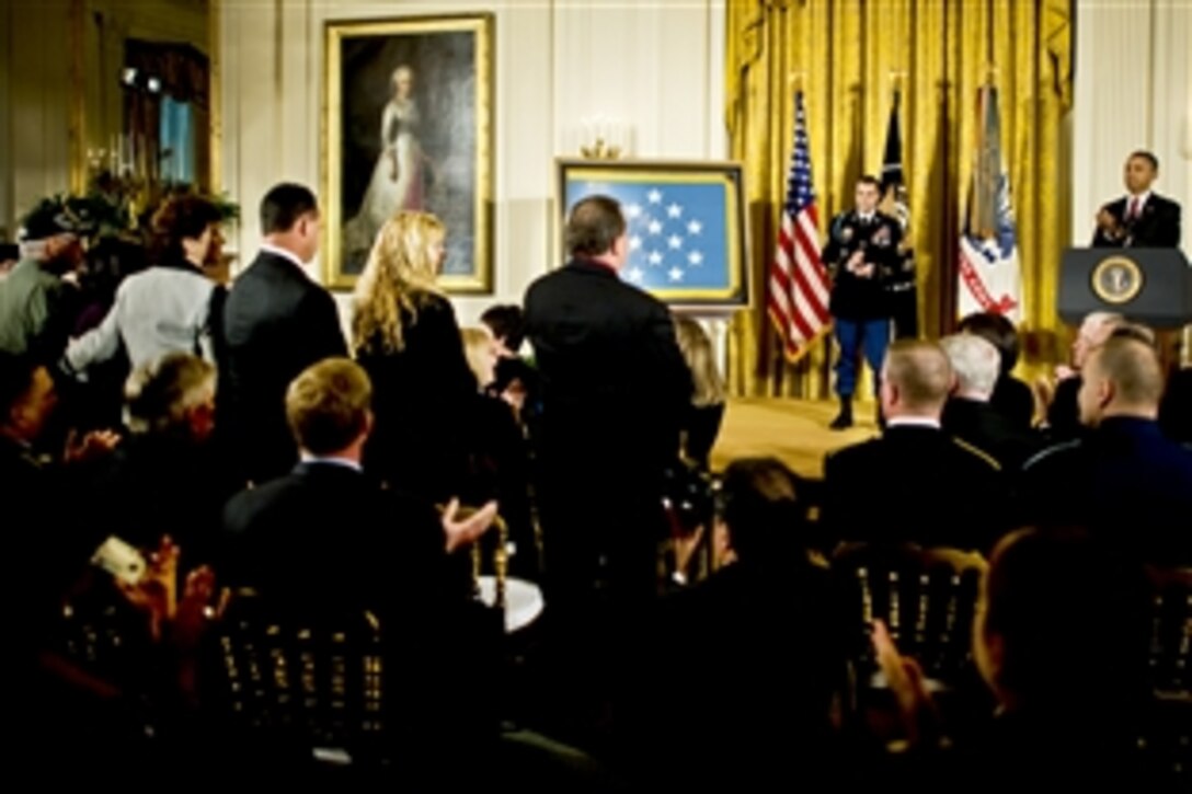 President Barack Obama and Army Staff Sgt. Salvatore Giunta appluad the family of a soldier who gave his life in Afghanistan during Giunta's Medal of Honor ceremony at the White House in Washington, D.C., Nov. 16, 2010. Giunta, of Hiawatha, Iowa, is the first living veteran from the wars in Iraq and Afghanistan to receive the award.