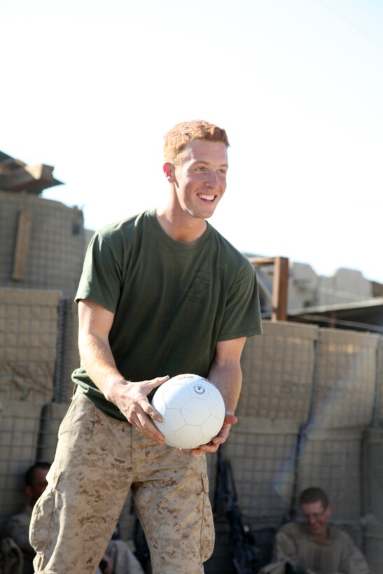 Sergeant Matthew Owen, a squad leader with India Company, 3rd Battalion, 5th Marine Regiment, smiles as he prepares to serve the volleyball during a friendly game against the Afghan National Army at ANA Post Nabi, Nov. 16, 2010. Owen, a 23-year-old native of Arroyo Grande, Calif., and fellow Marines challenged the ANA to a friendly game during a visit to their base.