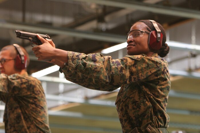 Cpl. Princess V. Woodside, Wolf- Tactical Reconnaissance and Personal Protection participant, concentrates on achieving correct sight picture in order to shoot a well aimed shot Nov. 17 at the Indoor Small Arms Range here. Marines and sailors executed several different types of drills. The point of the drills is to become comfortable with the firearm, be able to draw from the holster and achieve smooth presentation, tansitions and accurate shots.