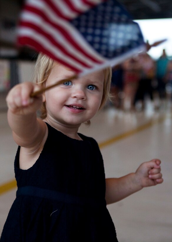 The 21-month-old daughter of Lt. Cmdr. Alan Miller, training officer, Patrol Squadron 9, waves an American flag and greets her father as he returns to Marine Corps Air Station Kaneohe Bay, Hawaii, from a six-month deployment, Nov. 16, 2010. During the deployment, VP-9 detached throughout the Navy’s 5th and 7th Fleet areas of responsibility. A group of VP-9 P-3s supported 5th Fleet maritime operations in Operation Iraqi Freedom from Isa Air Base in Bahrain. From their hub at Kadena Air Base, the remaining portion of VP-9 detached throughout the 7th Fleet AOR, working with a variety of coalition partners including Guam, Indonesia, Malaysia, the Philippines, Singapore, South Korea and Thailand.