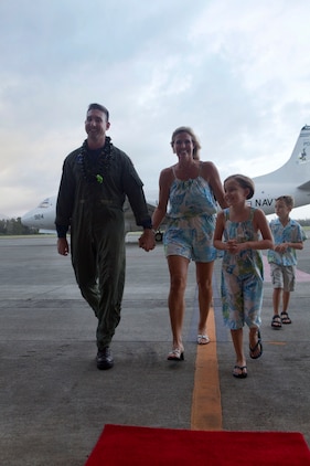 Cmdr. Rich Prest, executive officer, Patrol Squadron 9, walks into Hangar 105 with his family after returning to Marine Corps Air Station Kaneohe Bay, Hawaii, from a six-month deployment, Nov. 16, 2010. During the deployment, VP-9 detached throughout the Navy’s 5th and 7th Fleet areas of responsibility. A group of VP-9 P-3s supported 5th Fleet maritime operations in Operation Iraqi Freedom from Isa Air Base in Bahrain. From their hub at Kadena Air Base, the remaining portion of VP-9 detached throughout the 7th Fleet AOR, working with a variety of coalition partners including Guam, Indonesia, Malaysia, the Philippines, Singapore, South Korea and Thailand.