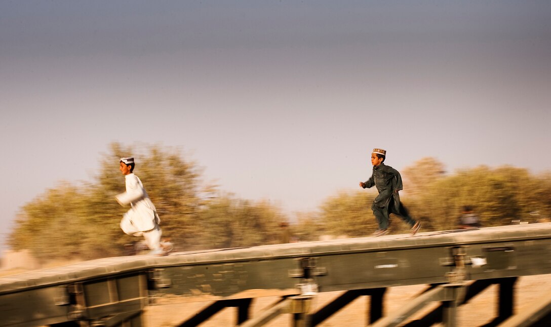 Local Afghan boys sprint across a bridge in Nawa, Afghanistan, to receive gifts for the Muslim Holiday of Id al-Adha, the Feast of Sacrifice, Nov. 17, 2010. Marines from 3rd Battalion, 3rd Marine Regiment, provided security while Afghan National Army Soldiers and U.S. Army personnel gave out supplies as a goodwill gesture during the second day of Id al-Adha. Within 15 minutes more than 300 gifts were given out. Marines and Afghan forces held three similar events across the Helmand province.