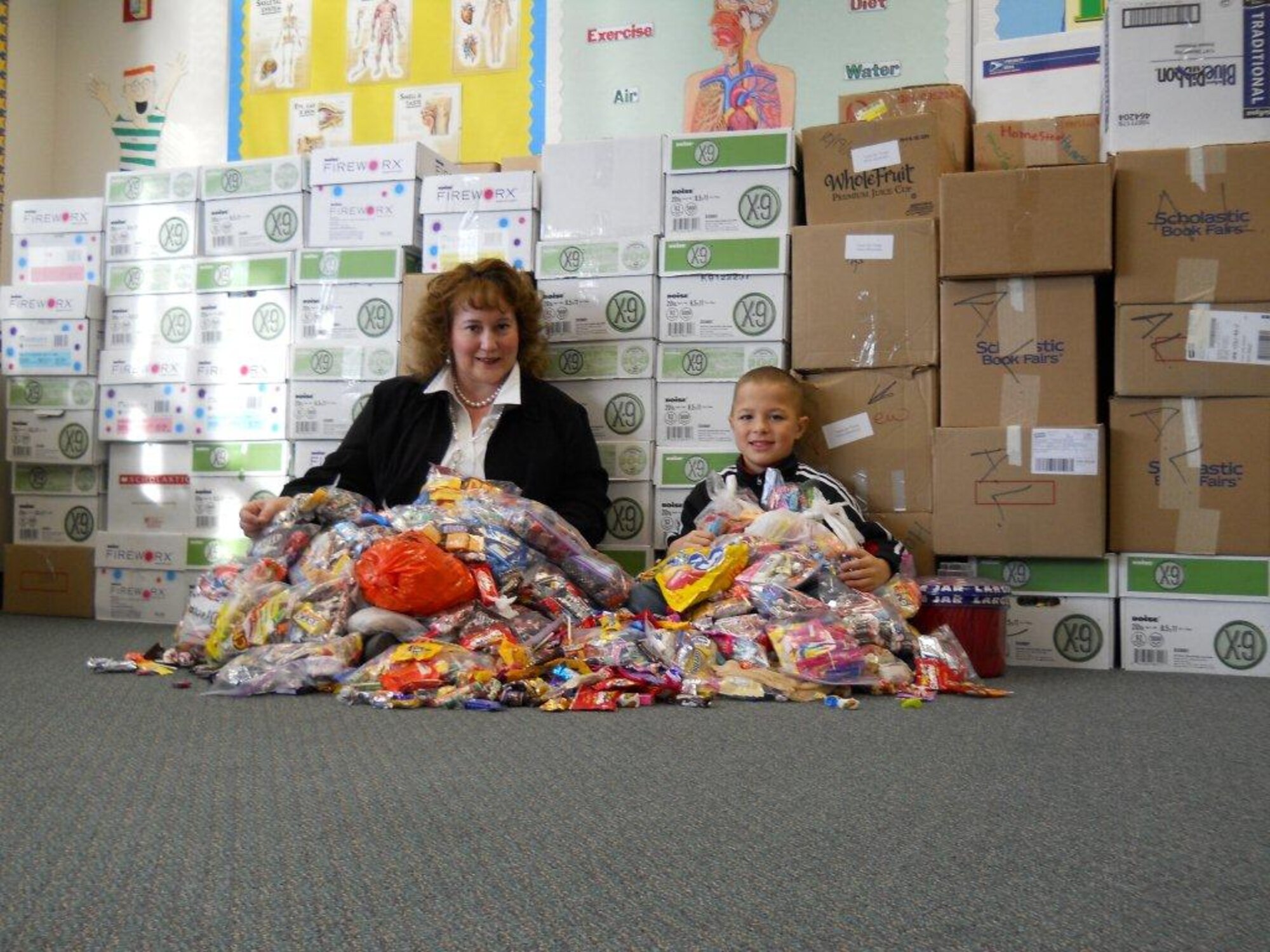 Melanie Sutton, Anchorage School District health specialist, sits under a mountain of candy with student Stephen Fletcher. (Courtesy photo)