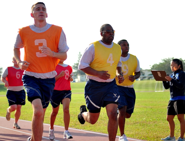 Five Kadena Airmen are monitored during the running portion of their fitness exam Nov. 10. Each Airmen must run six laps, or 1.5 miles, on the track at the Risner Fitness Center during official PT tests. For men under 30 years old, the time to beat is 13:36; for women under 30, the passing time is 16:22. (U.S. Air Force photo/Airman 1st Class Tara A. Williamson) 

