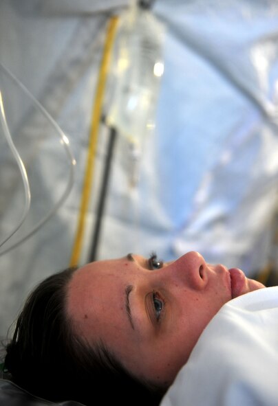 MOODY AIR FORCE BASE, Ga.-- Airman 1st Class Magen Faggart, 71st Rescue Squadron aircrew member, lies on a gurney as a medical patient during a Phase II Operational Readiness Exercise Nov. 16. Airman Faggart played as a joint terminal attack controller who was wounded in the thigh and received self-aid and buddy care before being stabilized at the make-shift hospital. (U.S. Air Force Photo/Airman 1st Class Joshua Green)(RELEASED)          