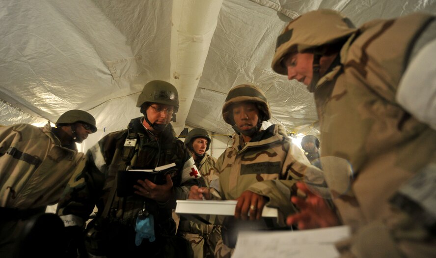 MOODY AIR FORCE BASE, Ga.-- Airmen from the 23rd Medical Group discuss what route to take and positions to assign, all the while providing care to a member wounded in the field during a Phase II Operational Readiness Exercise Nov. 16. Members from the 23rd MDG were tasked with three casualty victims: two wounded in battle and one nonbattle injury. (U.S. Air Force Photo/Airman 1st Class Joshua Green)(RELEASED)          