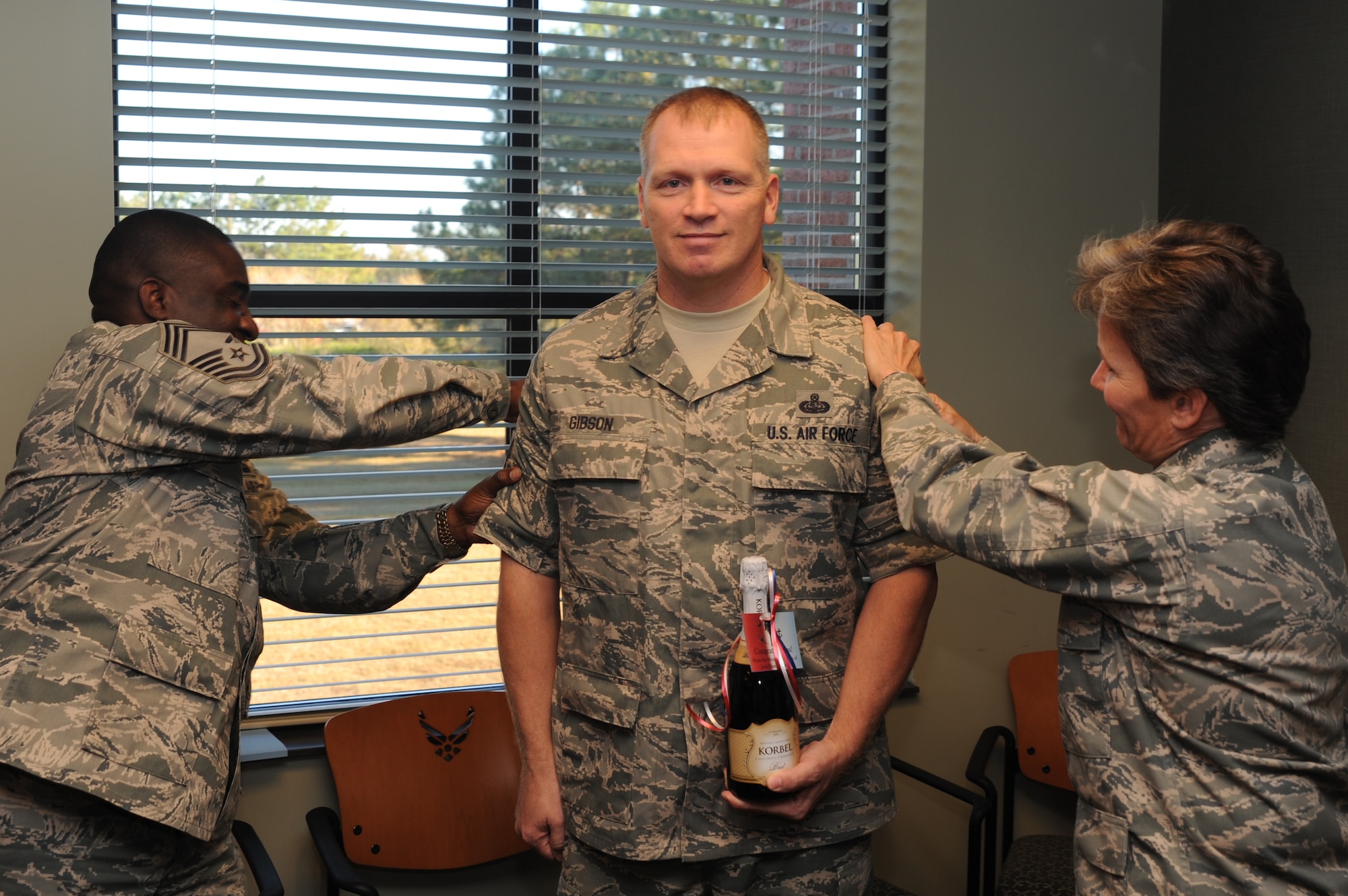 U.S. Air Force Col. Martha Meeker, right, and Chief Master Sgt. Thomas Jackson, left, tack chief master sergeant stripes onto Senior Master Sgt. Michael Gibson after he was notified of his selection for promotion Nov. 17, 2010, at Joint Base Charleston, S.C. Air Force officials selected 504 of 2,287 eligible senior master sergeants for promotion to chief master sergeant, for a selection rate of 22.04 percent. Colonel Meeker is the Joint Base Charleston commander and Chief Jackson is the acting 628th Air Base Wing command chief. Sergeant Gibson is the 628th Communications Squadron superintendent. (U.S. Air Force photo/Tech. Sgt. Chrissy Best)