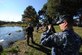 Master-at-Arms 1st Class Bill Carmer stands by with a shot gun in hand as employees from Gator Getters Consultants attempt to move Charlie the alligator from his home Nov. 17, 2010, Joint Base Charleston-Weapons Station, S.C. Charlie is being temporarily moved for pond cleaning, overflow structure improvements and increased pond depth of eight feet. There will also be two dens built in the pond so Charlie and the other alligators can hibernate. MA1 Carmer is a security forces member with the 628th Security Forces Squadron. (U.S. Air Force photo/James M. Bowman)