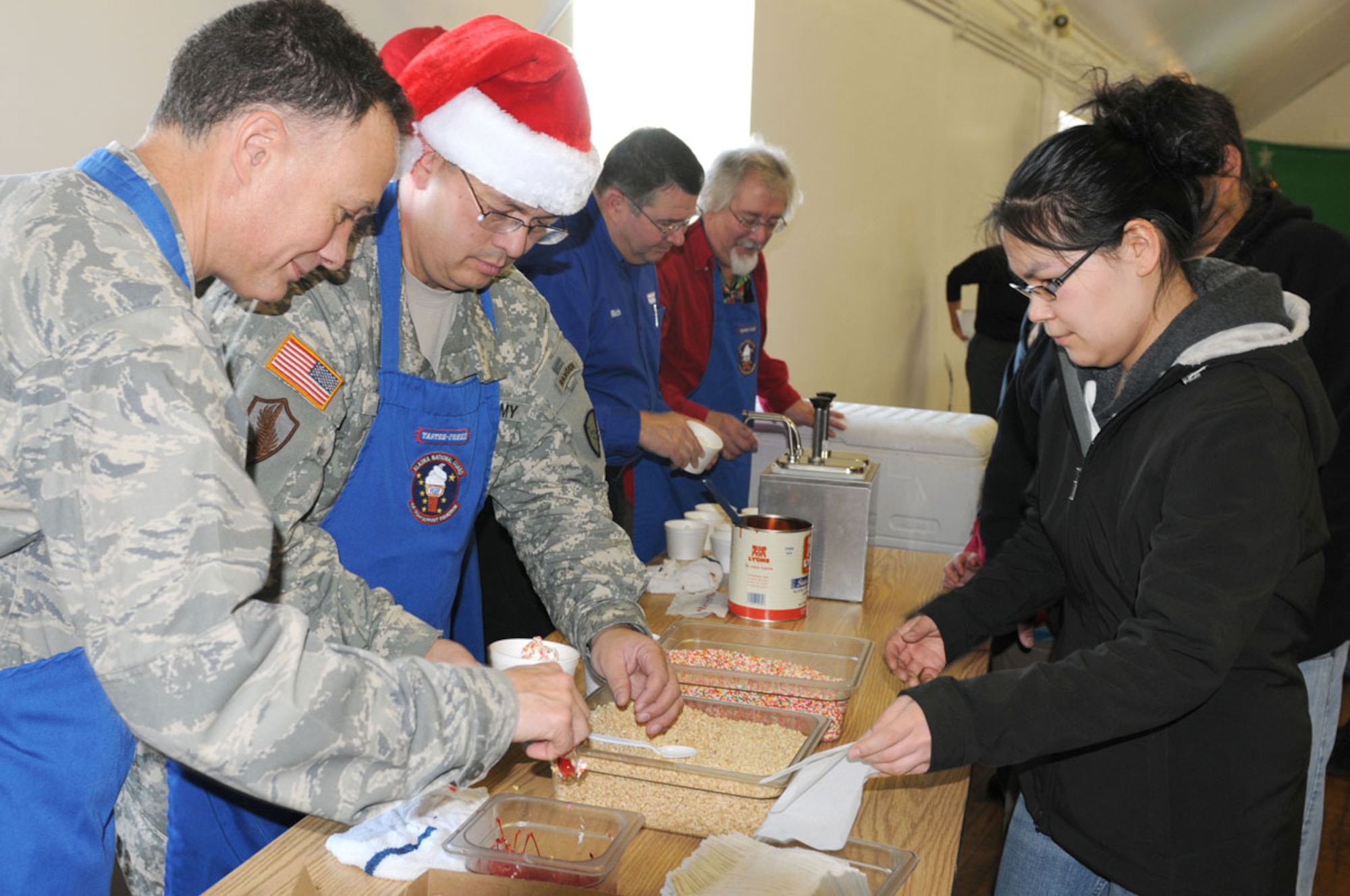 (Left to right) Guardsmen Col. Andy Mamrol and Brig. Gen. Randy J. Banez prepare sundaes to give to the residents of St. Paul during Operation Santa Claus Nov. 6. The sundaes were provided by Rich Owens, owner of Tastee Freez, a local family-owned eatery in Anchorage.  (Alaska Army National Guard photo/Pfc. Karina Paraoan)