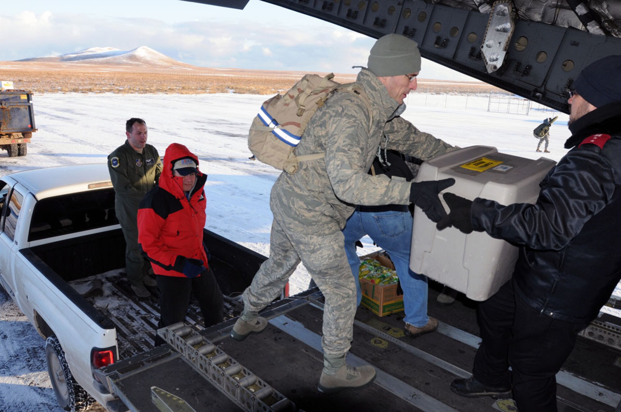 Members of the Alaska Air National Guard and volunteer members from different organizations work together to unload the many tubs of food for the families of St. Paul during Operation Santa Claus Nov. 6.  (Alaska Army National Guard photo/Pfc. Karina Paraoan)