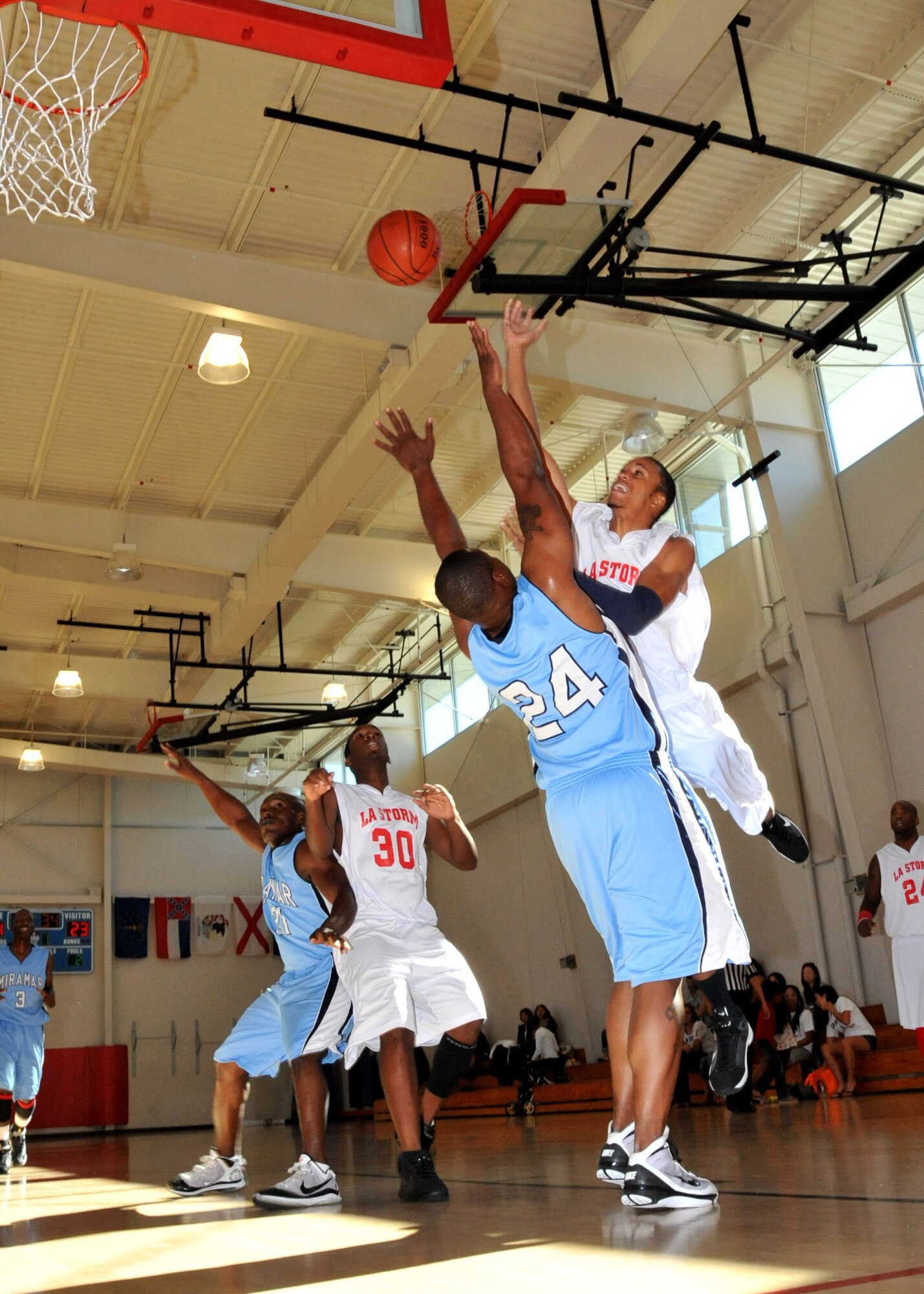 LA Storm team member Devin Reed battles with a player (no. 24) from Miramar Air Station for control of the ball during military basketball league play here, Nov. 13. The Storm won 79 to 71. (Photo by  Lou Hernandez)