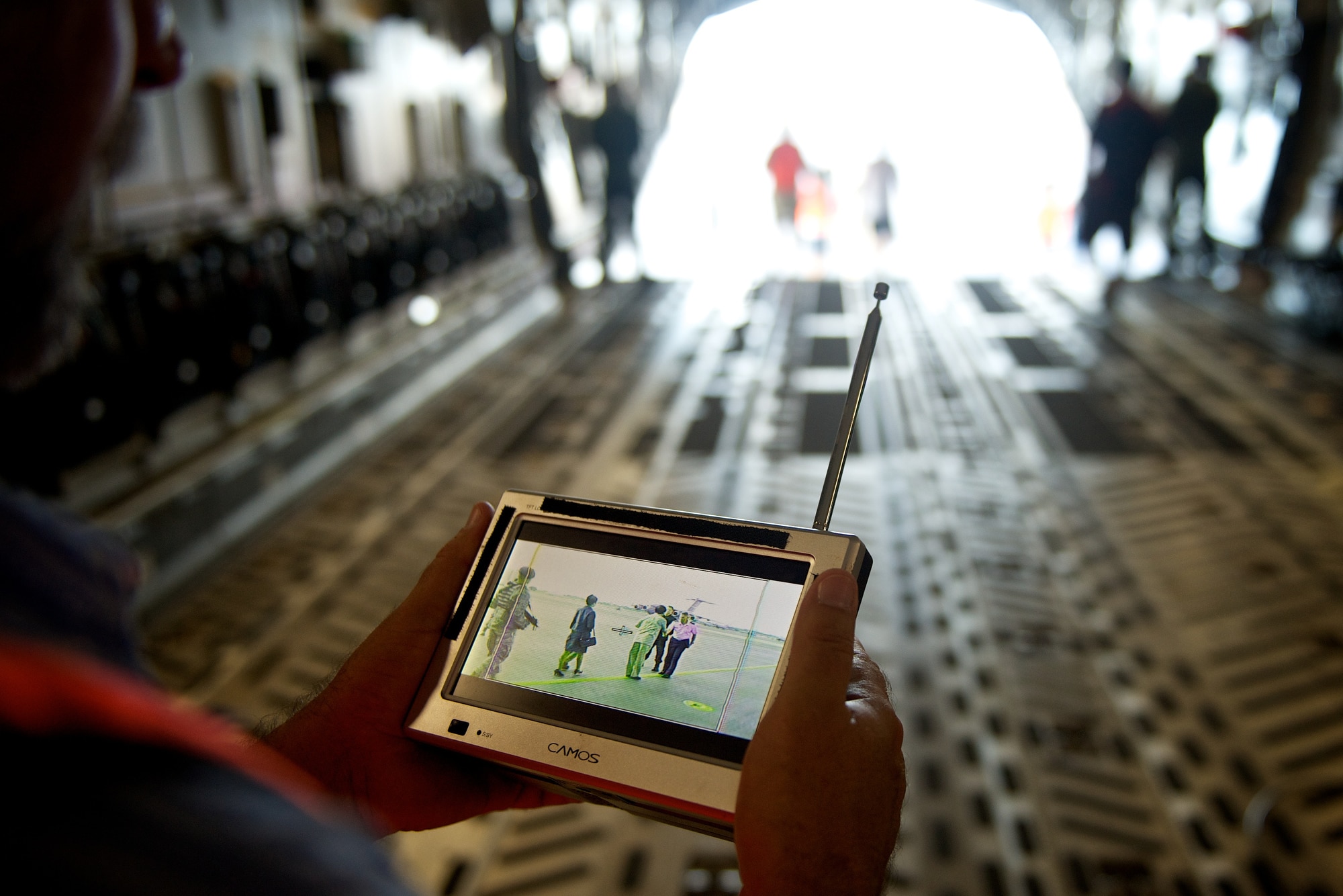 A Hawaii Five-0 film crew member watches a scene on a remote monitor as it is filmed on the back of a C-17 Globemaster III on Oct. 11. The cast and crew of the hit show are on Joint Base Pearl Harbor-Hickam filming scenes for a recent episode. (U.S. Air Force Photo/Master Sgt. Jeffrey Allen)