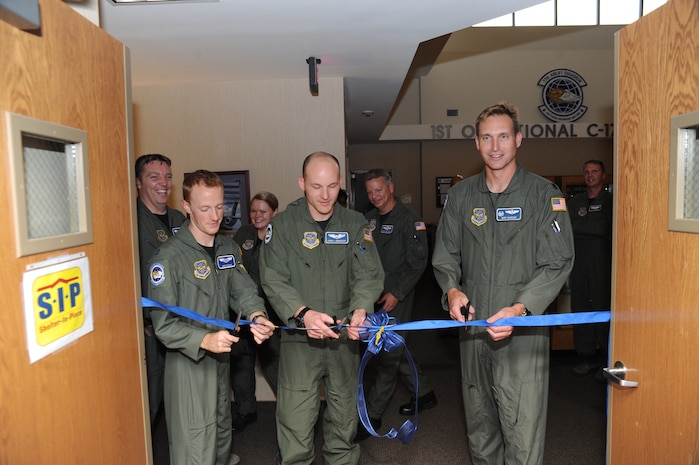 Lt.Col. Michael Madsen, right, Capt. Aaron Urbanovsky, center, and Capt. Chris Thomas officially open the doors to the 17th Airlift Squadron's newly renovated Heritage Room on Joint Base Charleston-Air Base, S.C., Nov. 16, 2010. Converted from its aged-state, the renovations transformed it into a space for building camaraderie and displaying squadron memorabilia and history. With the new improvements, the room is planned as a fitting venue for squadron meetings and group events. Colonel Madsen is the 17 AS commander, Captains Thomas and Urbanovsky are 17 AS pilots who worked as renovation project leaders. (U.S. Air Force photo/James Bowman)