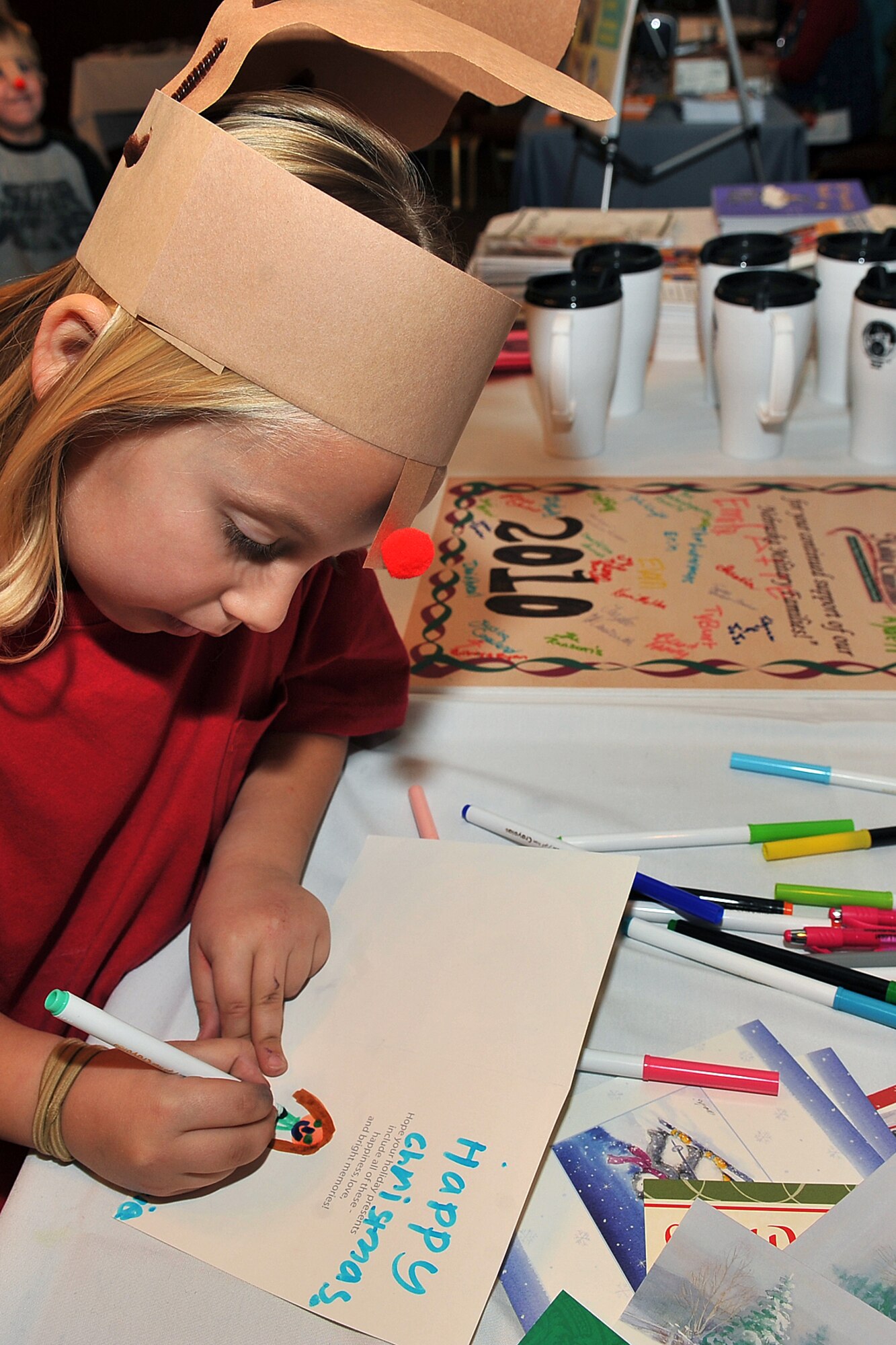 OFFUTT AIR FORCE BASE, Neb. -- Mackenzie Cook, daughter of Staff Sgt. Jeffrey Cook, makes a card for deployed troops during holiday connections in the Community Center here Nov.16. More than 100 Team Offutt families attended and made gifts, cards and video messages for their loved ones who will be away from home this holiday season. The annual event, established in 2000, provides a fun environment  for families to come together and share a little joy.
U.S. Air Force photo by Charles Haymond