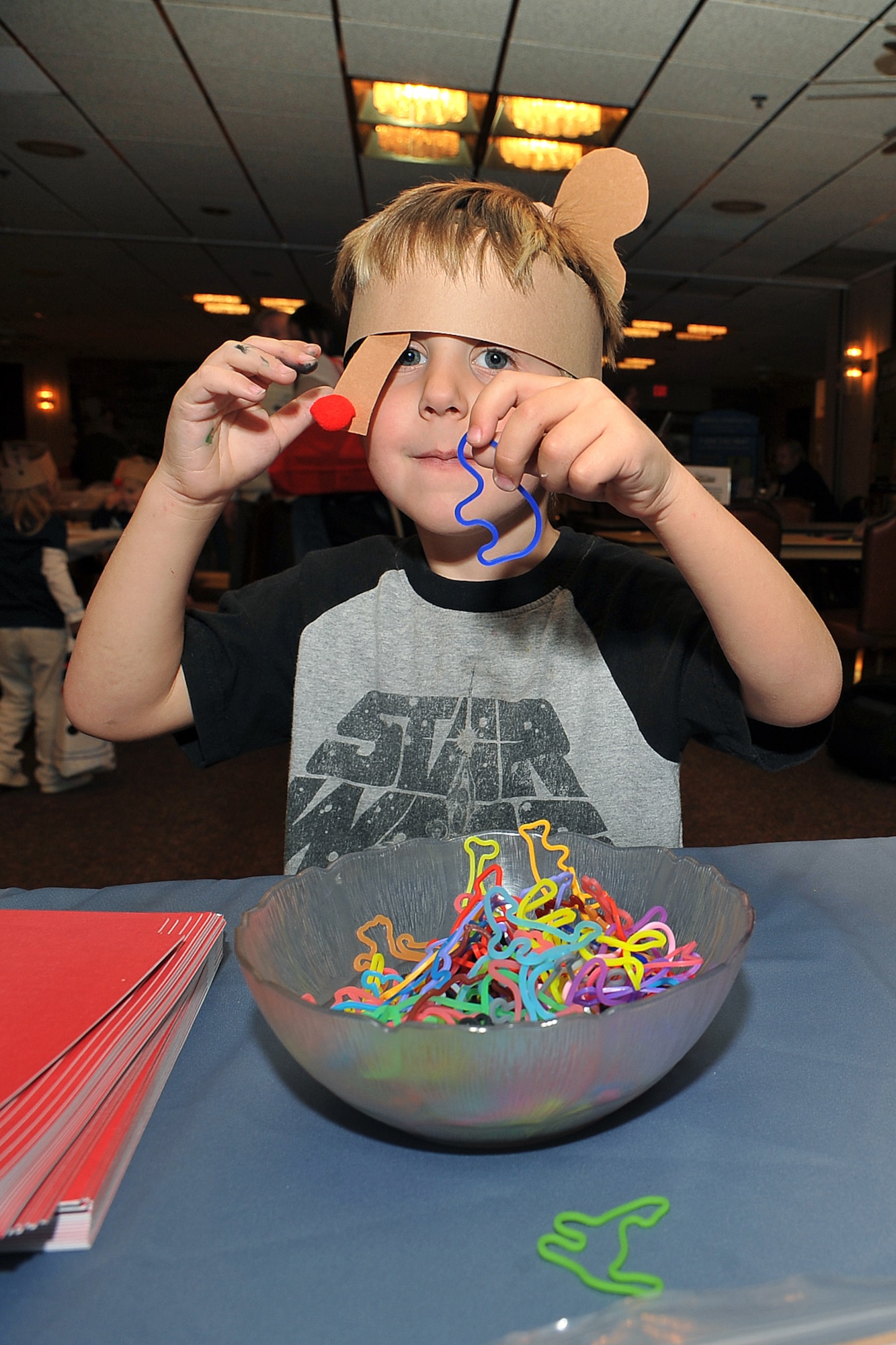 OFFUTT AIR FORCE BASE, Neb. -- Elliott Cook, son of Staff Sgt. Jeffery Cook, holds up a bracelet he selected during holiday connections in the Community Center here Nov. 16. More than 100 Team Offutt families attended and made gifts, cards and video messages for their loved ones who will be away from home this holiday season. The annual event, established in 2000, provides a fun environment  for families to come together and share a little joy.
U.S. Air Force Photo by Charles Haymond