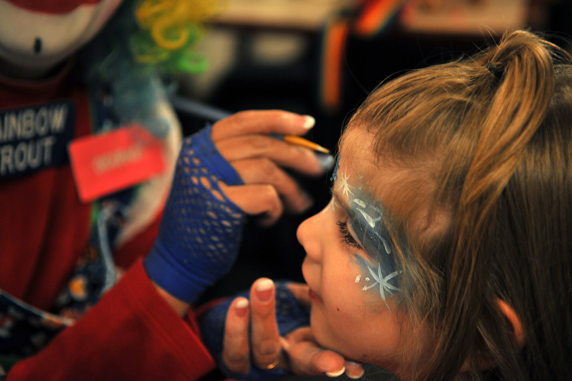 OFFUTT AIR FORCE BASE, Neb. -- Kami Cole, step daughter of Capt. Howard Moore, gets her face painted by Donna Trout, also known as Rainbow Trout the clown, during holiday connections in the Community Center here Nov. 16. More than 100 Team Offutt families attended and made gifts, cards and video messages for their loved ones who will be away from home this holiday season. The annual event, established in 2000, provides a fun environment  for families to come together and share a little joy.
U.S. Air Force Photo by Charles Haymond