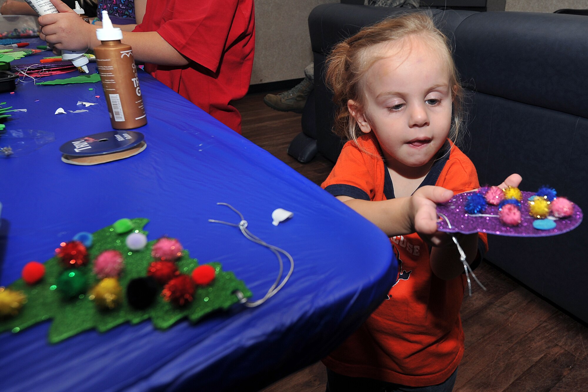 OFFUTT AIR FORCE BASE, Neb. -- Emily Cook, daughter of Staff Sgt. Jeffery Cook, makes a Christmas tree ornament during holiday connections in the Community Center here Nov. 16. More than 100 Team Offutt families attended and made gifts, cards and video messages for their loved ones who will be away from home this holiday season. The annual event, established in 2000, provides a fun environment  for families to come together and share a little joy.
U.S. Air Force Photo by Charles Haymond