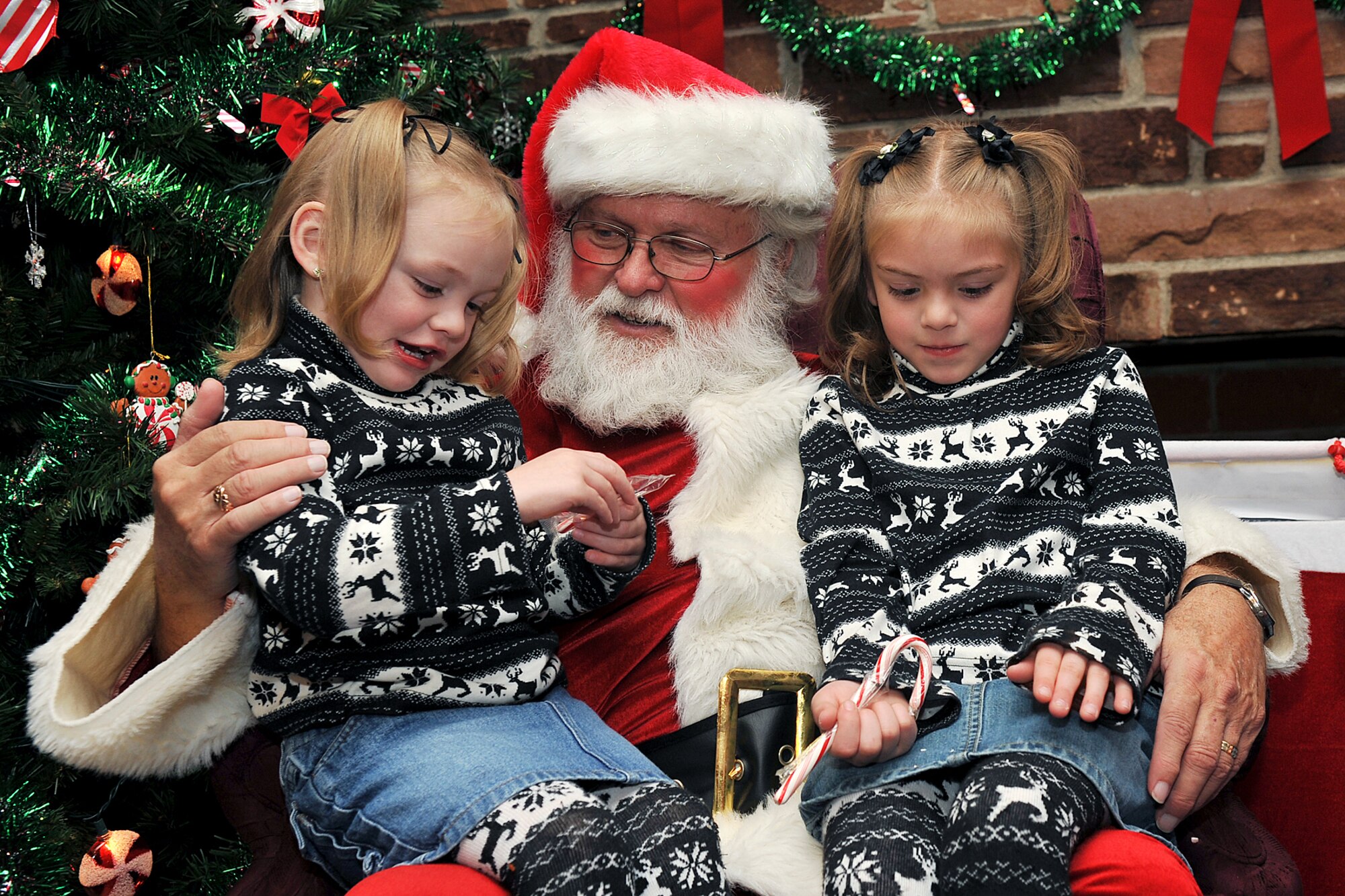 OFFUTT AIR FORCE BASE, Neb. -- Alaina and Caitlin Nelson, daughters of Staff Sgt. Michael Nelson, tell Santa what they want for Christmas during the holiday connection event in the Community Center here Nov. 16. More than 100 Team Offutt families attended and made gifts, cards and video messages for their loved ones who will be away from home this holiday season. The annual event, established in 2000, provides a fun environment  for families to come together and share a little joy. U.S. Air Force photo by Charles Haymond