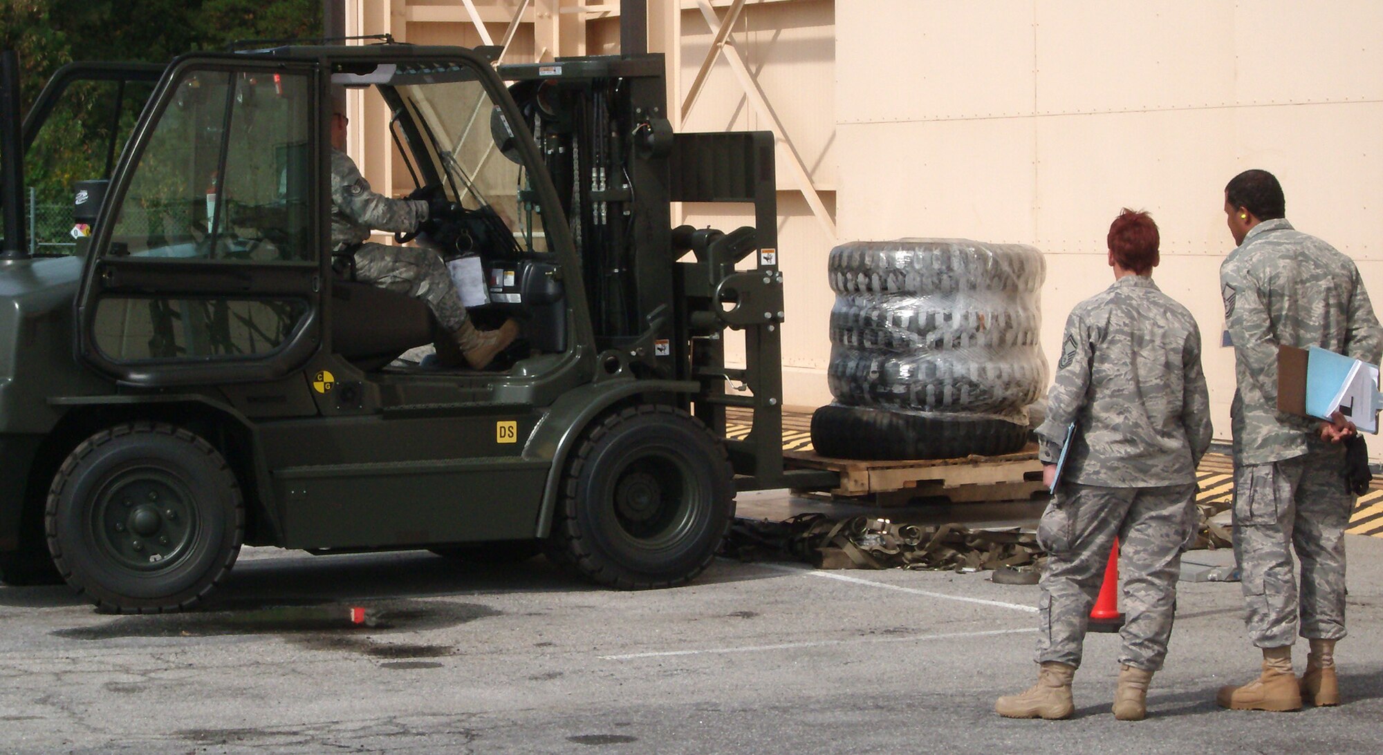 Air Force Reserve Command evaluators  look on as Tech. Sgt. Jeremy Jamison gently moves his forklift in place during a 10K forklift pallet build up competition Oct. 28 at Dobbins Air Reserve Base, Ga. Sergeant Jamison and other AF Reservists represented the 39th Aerial Port Squadron Oct. 25-29 during the inaugural Air Force Reserve Command Port Dawg Challenge. The event brought together 23 aerial port squadrons in a number of friendly competitions, testing Reservists' speed and accuracy in a variety of aerial port challenges common to the career field. The 39th APS took first place in the timed forklift driving course, while the overall Port Dawg Challenge winners were the 27th APS from Minneapolis-St. Paul Air Reserve Station, Minn. The 39th APS is a subordinate organization to the Colorado-based 302nd Airlift Wing. (U.S. Air Force photo/Lt. Col. Michael Burns)