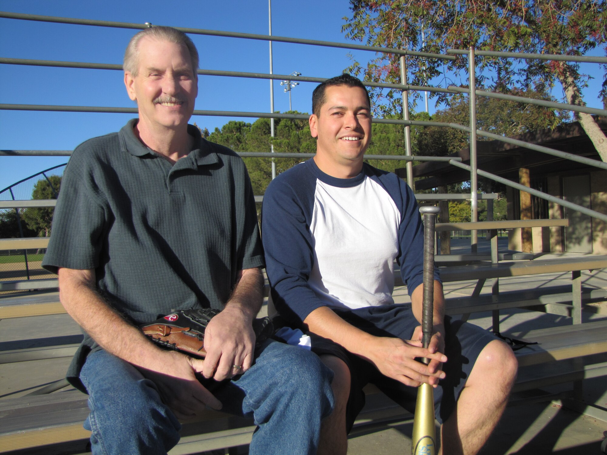 Rob Welsh (left), a 30-year Lockheed Martin employee, and Manuel Jaramillo, 95th Air Base Wing Environmental Restoration specialist, take a seat in the bleachers at a Lancaster, Calif. city park Nov. 12. Mr. Jaramillo performed cardiopulmonary resuscitation on Mr. Welsh when he suffered a heart attack during a softball game in Lancaster, Aug. 15. (Air Force photo by Staff Sgt. Angelique Smythe)