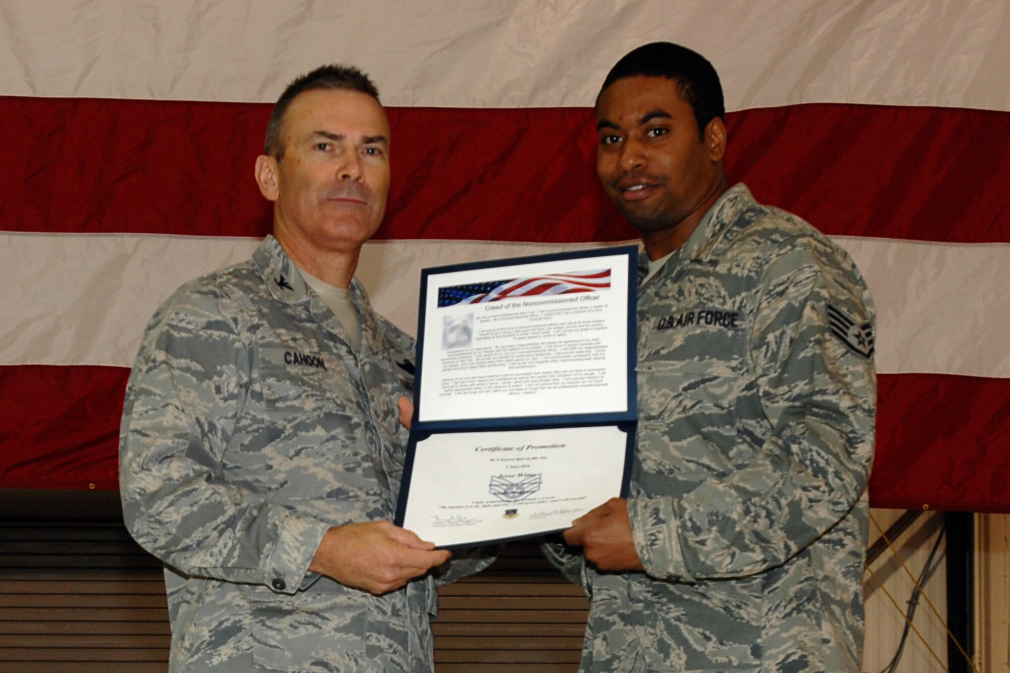 GRISSOM AIR RESERVE BASE, Ind. -- Staff Sgt. Jesse Wims is presented with a certificate of promotion by Col. William T. "Tim" Cahoon during a special induction ceremony held here during the November unit training assembly. Sergeant Wims, a traffic management specialist with the 434th Logistics Readiness Squadron, along with 18 other Grissom Airmen inducted into the noncommissioned officer ranks. Colonel Cahoon is the 434th Air Refueling Wing commander. (U.S. Air Force photo/Senior Airman Carl Berry)
