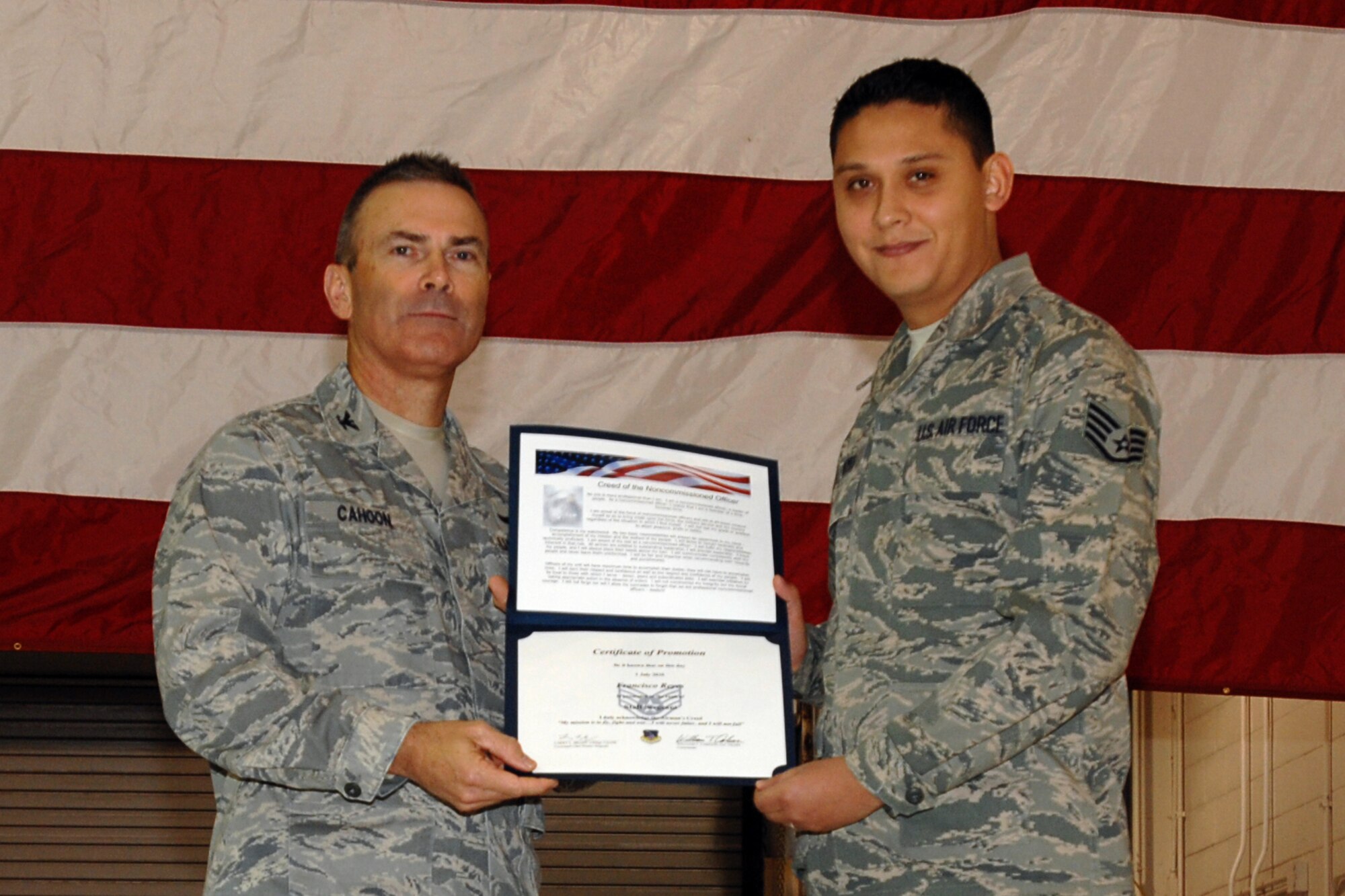 GRISSOM AIR RESERVE BASE, Ind. -- Staff Sgt. Francisco Reyes is presented with a certificate of promotion by Col. William T. "Tim" Cahoon during a special induction ceremony held here during the November unit training assembly. Sergeant Reyes, a traffic management specialist with the 434th Logistics Readiness Squadron, along with 18 other Grissom Airmen inducted into the noncommissioned officer ranks. Colonel Cahoon is the 434th Air Refueling Wing commander. (U.S. Air Force photo/Senior Airman Carl Berry)
