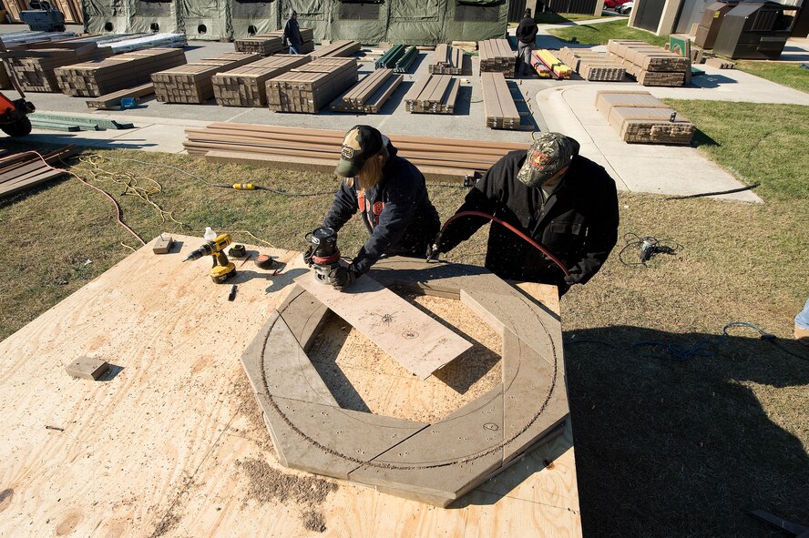 Base volunteers prepare wood for construction of a new playground being built next to the base swimming pool at Dover AFB, De., Nov. 7, 2010. Wing leadership directed a portion of funds obtained from winning the 2010 Air Mobility Command's Commander-in-Chief's Award for Installation Excellence for the park’s construction.  The playground, designed by Leathers and Associates, features swings, slides and other play areas contained inside a huge shell resembling a large cargo military aircraft. It could be a C-17 or a C-5, depending on how you look at it. The park is being built by more than 900 base volunteers. (U.S. Air Force Photo/Jason Minto)