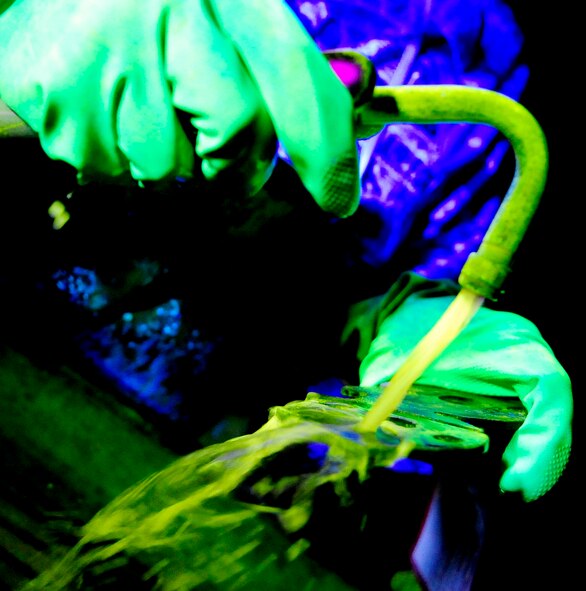 RAF MILDENHALL, England -- A KC-135 Stratotanker up-lock bracket is sprayed with a florescent magnetic bath during a magnetic particle inspection Nov. 16, 2010. The KC-135 up-lock bracket is sprayed with the bath to fill any cracks that may be present and can be distinguished under a black light. (U.S. Air Force photo/Senior Airman Ethan Morgan)