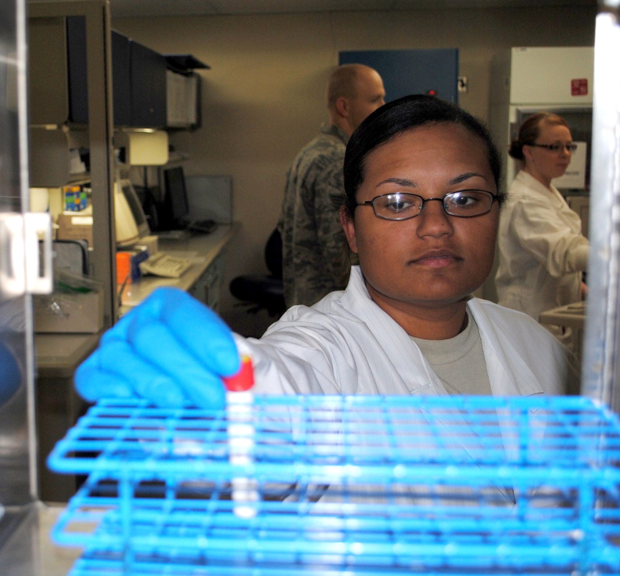 Senior Airman Tambara Hamilton, 341st Medical Group clinical laboratory technician, retrieves a test vile from a sample rack to analyze in the laboratory centrifuge Nov. 11. (U.S. Air Force photo/Airman 1st Class Kristina Overton)