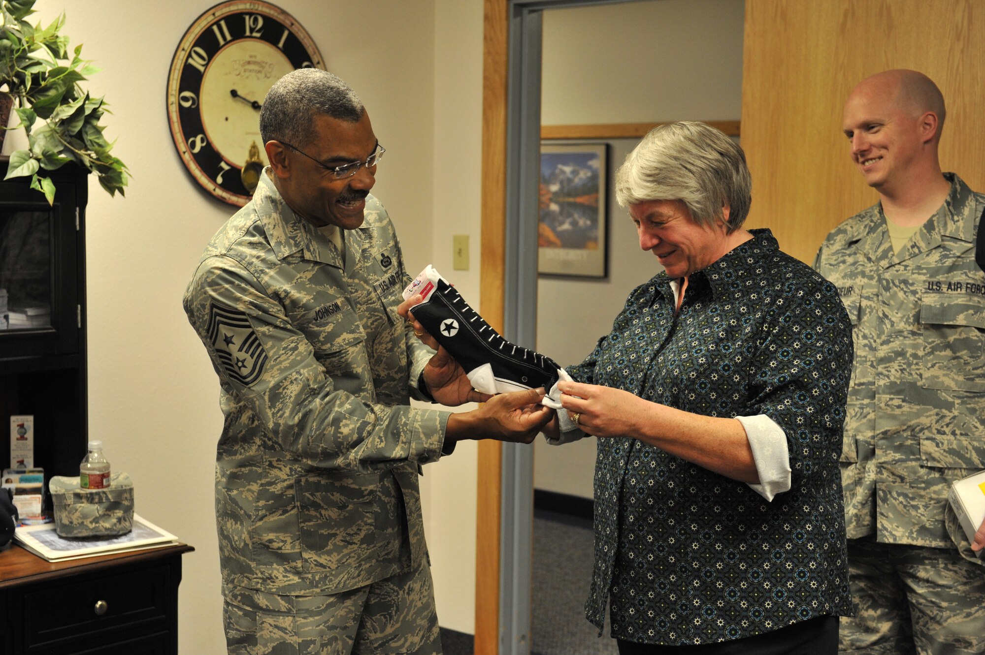 Chief Master Sgt. Jack Johnson, Air Force Global Strike Command command chief master sergeant, and Carolyn Dowdy, 341st Missile Security Forces Squadron secretary and a victim advocate with the 341st Missile Wing’s Sexual Assault Response Coordination office, discuss one of the promotional items that the SARC office gives away to advertise its services.  Staff Sgt. Michael Stordeur, 341st Force Support Squadron and victim advocate, looks on.  (U.S. Air Force photo/ John Turner)