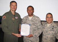 Master Sgt. Melvin Benton, 919th Logistics Readiness Squadron, (center)  proudly displays the official order that recently promoted him to the rank of master sergeant.  While away on a temporary duty assignment at Luke Air Force Base, Ariz., the Duke Field reservist received his new stripes in a surprise presentation by Col. Michael Popovich, 944th Fighter Wing commander (left) and Chief Master Sgt. Pablo Valverde, 944th FW command chief. Sergeant Benton was one of eight Duke Field reservists awarded immediate, on-the-spot Promotion Enhancement Program promotions during the wing’s October unit training assembly. The PEP is a commander’s program designed to promote outstanding and well-deserving Air Force Reserve Airmen one grade above the authorized grade for their position. Only those Airmen who show outstanding potential are considered based on a demonstrated ability to serve in the next higher grade. (Courtesy photo)