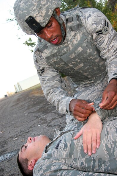 Airman 1st Class Michael Travis, 341st Security Forces Squadron Tactical Response Force breacher, improvises a sling on his wingman, Airman 1st Class Aaron Simpson, 341st SFS TRF team trainer, during self-aid and buddy care training Oct. 6 near the Warrior Launch Facility trainer. The Airmen combined land navigation, SABC, one-mile runs with gas masks and one-man carries during this particular day of training in preperation for competition in the 2010 Global Strike Challenge. (U.S. Air Force photo/Staff Sgt. Dillon White)