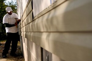 LANGLEY AIR FORCE BASE, Va. -- Tech. Sgt. Elroy Williams, Headquarters Air Combat Command Ceremony NCOIC, installs siding on a house during a Habitat for Humanity project Oct. 15. Sergeant Williams and his family received the Armed Forces YMCA of Hampton Roads’ Five-Star Air Force Military Family of the Year award for their collective contribution of community service, including volunteer work, organizing a foundation for military spouses and families to escape domestic violence, and serving on local schools’ parent-teacher associations. (Photo courtesy/Tech. Sgt. Elroy Williams)(RELEASED)