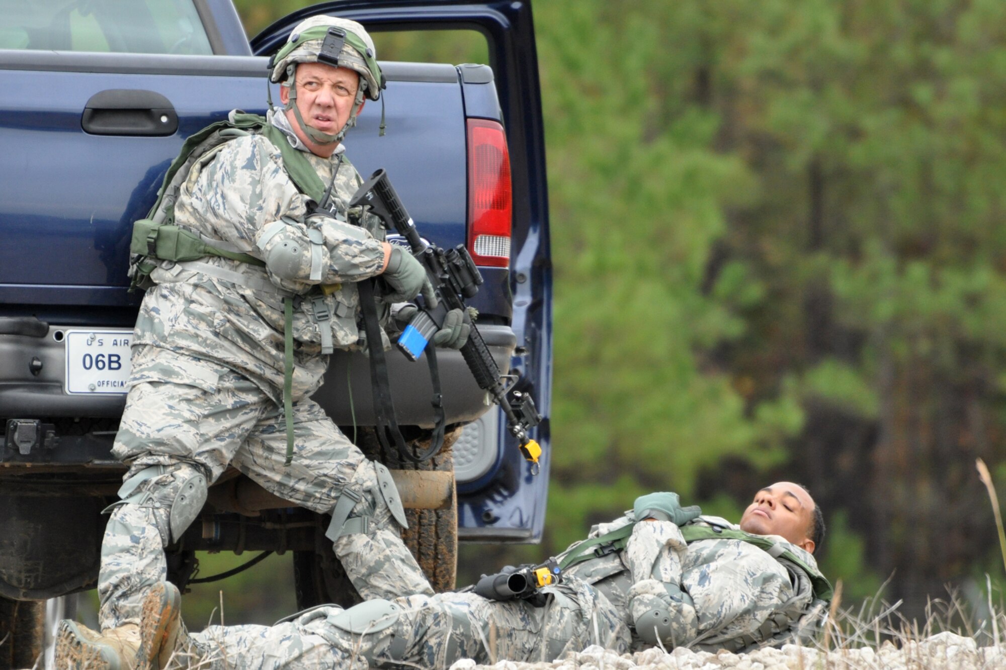 Technical Sgt. Melvin Cargill, a 917th Security Forces Squadron tactics team member, takes cover behind his truck during a firefight at a Firing and Tactics Event at Camp Minden in Louisiana, Nov. 13, 2010. Airman First Class Colby Newborn, who is lying on the ground, had already been designated as killed in action after being shot by aggressor forces. The event was part of the first-ever Global Strike Challenge, which wrapped up at Barksdale Air Force, La., Nov. 17, 2010. A six-man team from the 917th SFS competed in the event against other teams from numerous bases involved in the competition. (U.S. Air Force photo/Tech. Sgt. Jeff Walston)