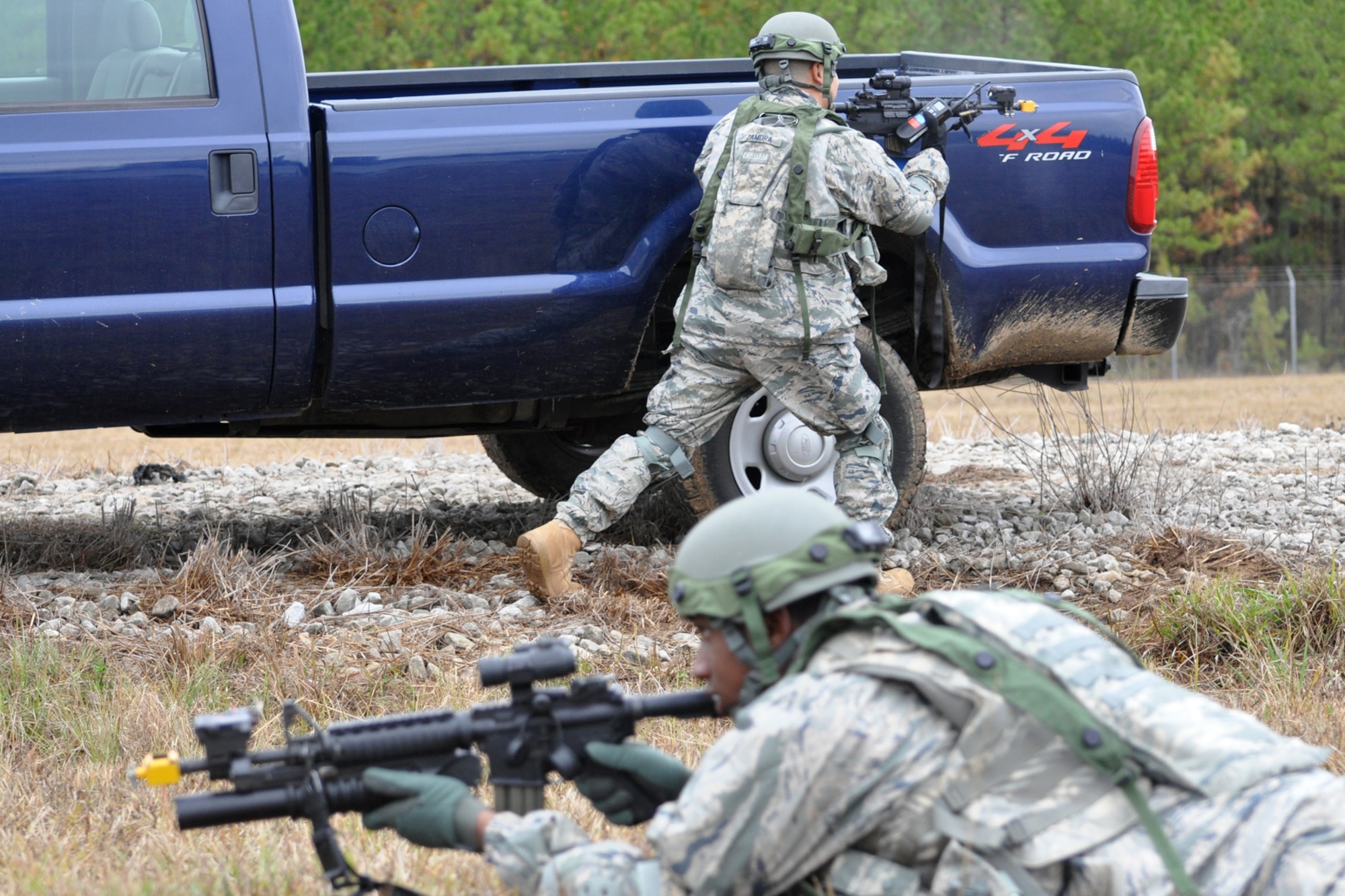 Airman First Class Trevor Forman and Technical Sgt. Daniel Zamora, members of the 917th Security Forces Squadron tactics team, return fire after being attacked by aggressor forces from two different directions during the Firing and Tactics Event at Camp Minden in Louisiana, Nov. 13, 2010. The event was part of the first-ever Global Strike Challenge, which wrapped up at Barksdale Air Force Base, La., Nov. 17, 2010. A six-man team from the 917th SFS competed in the event against other teams from numerous bases involved in the overall challenge. Sergeant Zamora was the team leader for the 917th SFS team. The Multiple Integrated Laser Engagement System or MILES, which uses lasers and blank cartridges to simulate actual battle, was used for the event to identify the Airmen who were killed. This system is used by the U.S. military and other armed forces around the world for training purposes. (U.S. Air Force photo/Tech. Sgt. Jeff Walston)