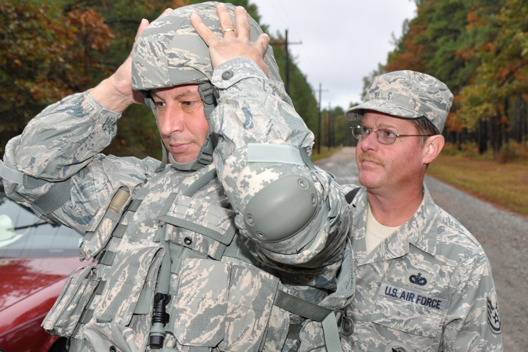 Staff Sgt. David Mudd, assists teammate Technical Sgt. Chad Turner with his headgear while gearing up for the Firing and Tactics Event at Camp Minden in Louisiana, Nov. 13, 2010. The event was part of the first-ever Global Strike Challenge. Sergeants Mudd and Turner are attached to the 917th Wing Security Forces Squadron at Barksdale Air Force Base, La. A six-man team from the 917th SFS competed in the event. Sergeant Mudd served as the alternate in the event of an injury to one of his teammates. (U.S. Air Force photo/Tech. Sgt. Jeff Walston)