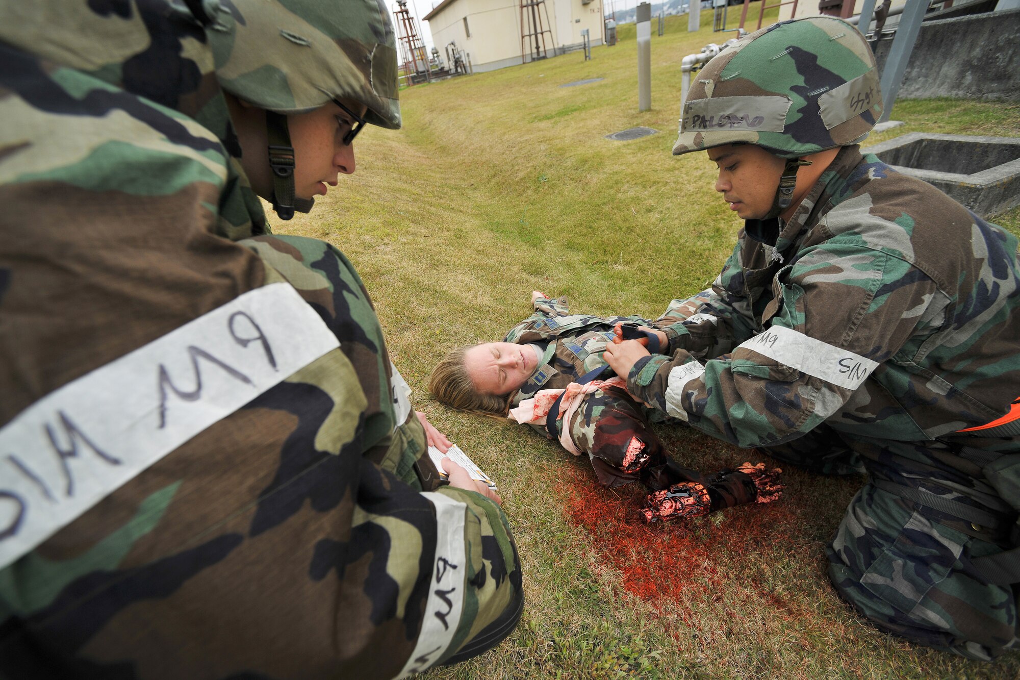 YOKOTA AIR BASE, Japan -- Airman 1st Class Christopher King (left) and Staff Sgt. Kane Palomo, both from the 374th Logistics Readiness Squadron, perform immobilization procedures on a simulated victim of a mortar attack here, Nov. 17 during a wing Operational Readiness Exercise. (U.S. Air Force photo/Osakabe Yasuo)