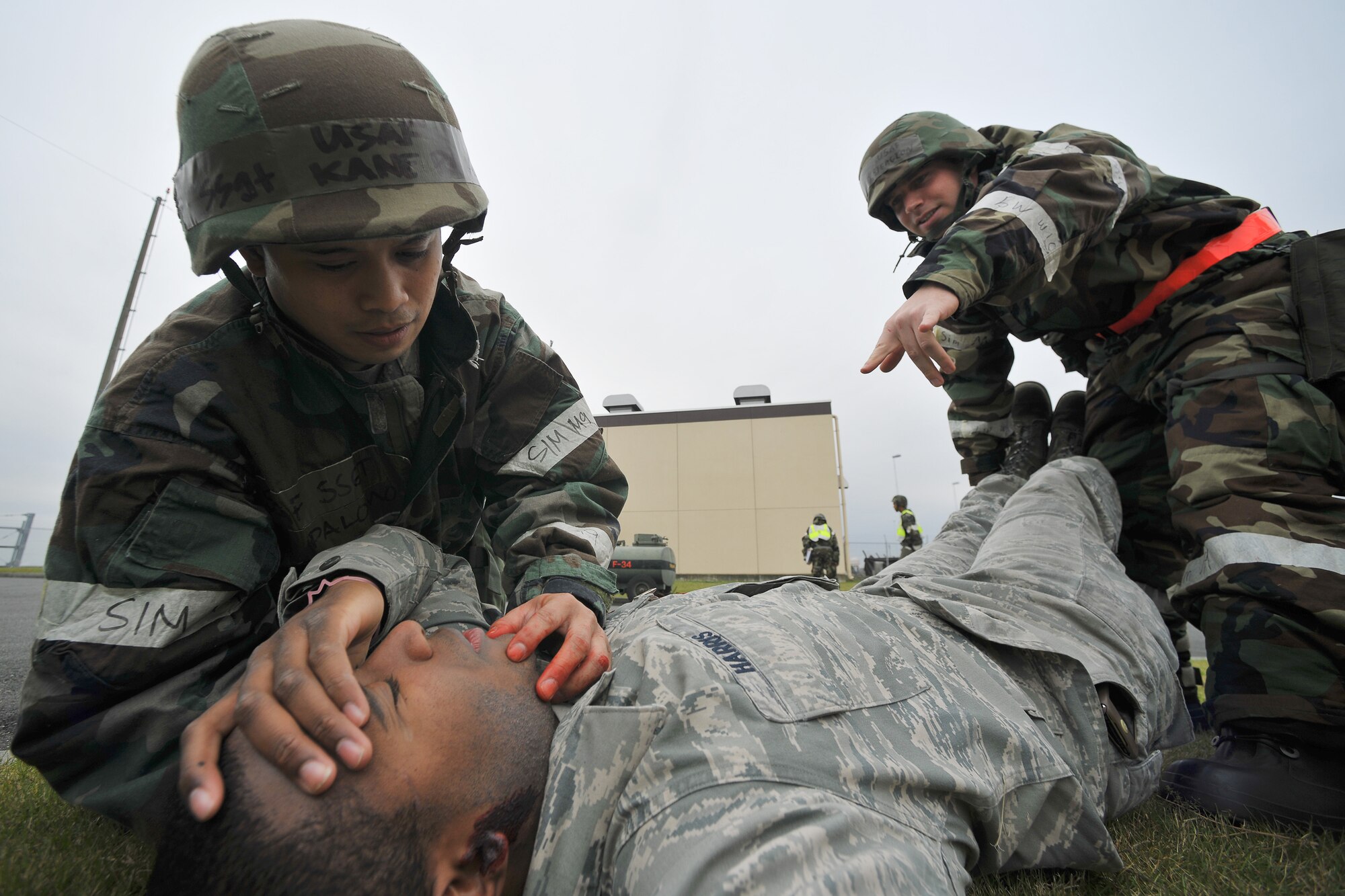 YOKOTA AIR BASE, Japan -- Staff Sgt. Kane Palomo (left) and Staff Sgt. David Stergion (right), both from the 374th Logistics Readiness Squadron, perform an immobilization procedure on a simulated mortar attack here Nov. 17. (U.S. Air Force photo/Osakabe Yasuo)