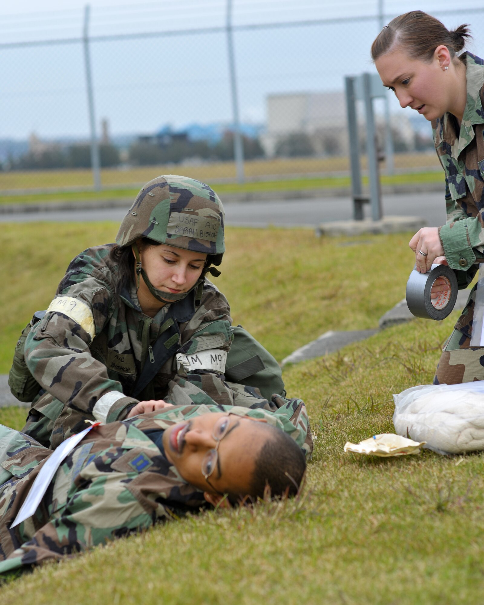 YOKOTA AIR BASE, Japan -- Airman 1st Class Sarah Bishop (right), 374th Logistics Readiness Squadron, and Senior Airman Joanne Higgins, 374th Maintenance Squadron, perform immobilization procedures on a simulated mortar attack victim here Nov. 17. (U.S. Air Force photo/Osakabe Yasuo)