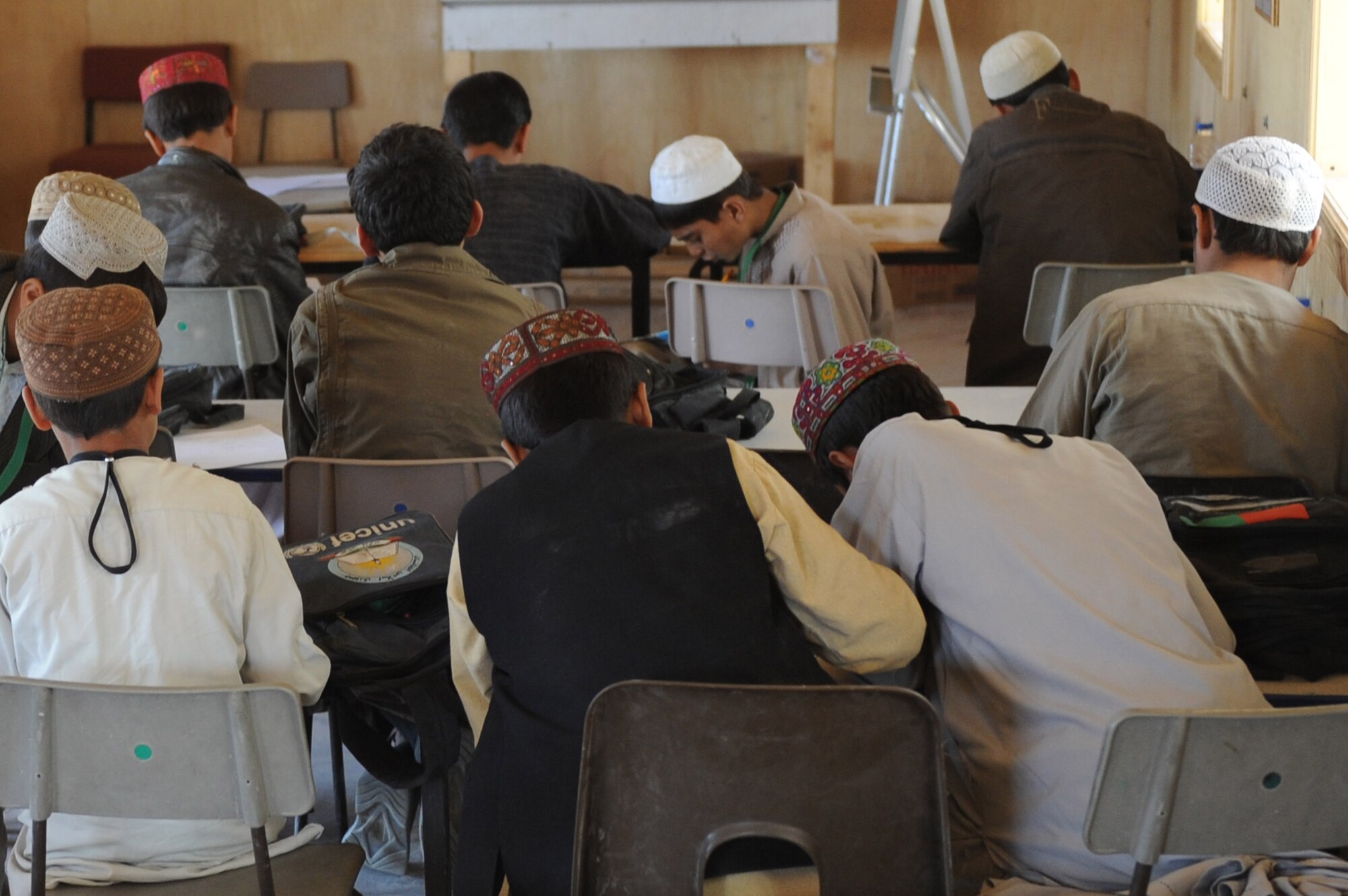 Afghan children prepare for class at the bazaar school Nov. 13, 2010, at Kandahar Airfield, Afghanistan.  A local Afghan man comes to the school to teach the older children English, while educating the younger children in a different on Arabic class work. (U.S. Air Force photo by Tech. Sgt. Chad Chisholm/Released) 