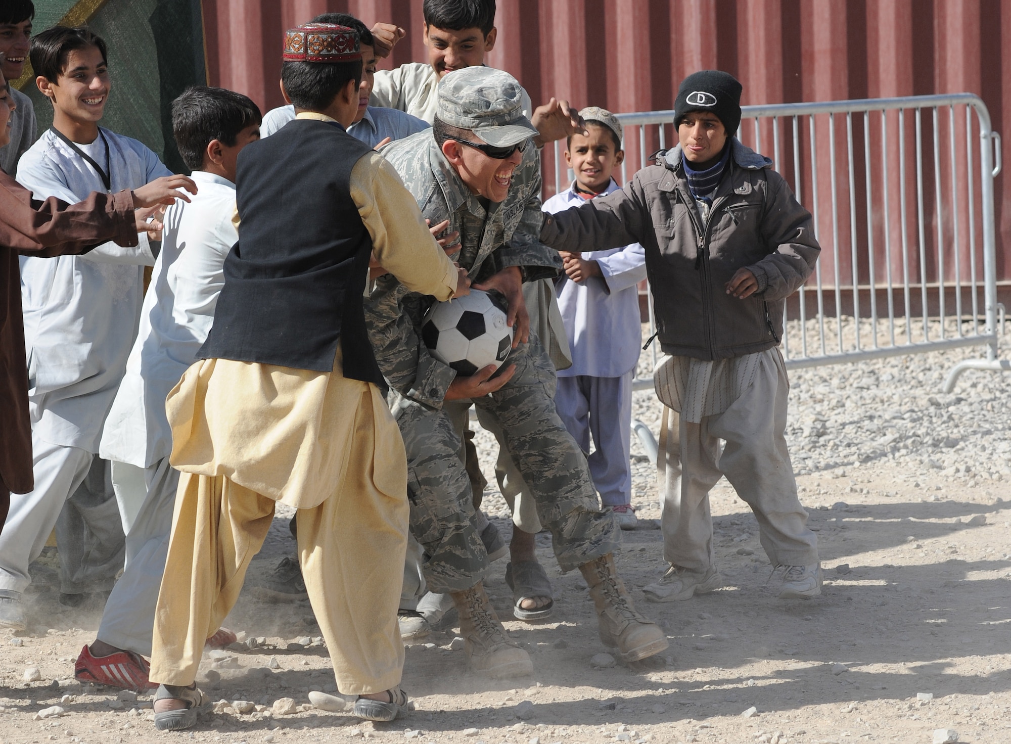 Senior Airman Jonathan Armstrong gets stopped with the soccer ball by local Afghan children while playing a game at the bazaar school Nov. 13, 2010, at Kandahar Airfield, Afghanistan. Airman Armstrong, from Fallon, Nev., is a vehicle operator and dispatcher assigned to the 451st Expeditionary Logistics Readiness Squadron. (U.S. Air Force photo by Tech. Sgt. Chad Chisholm/Released) 