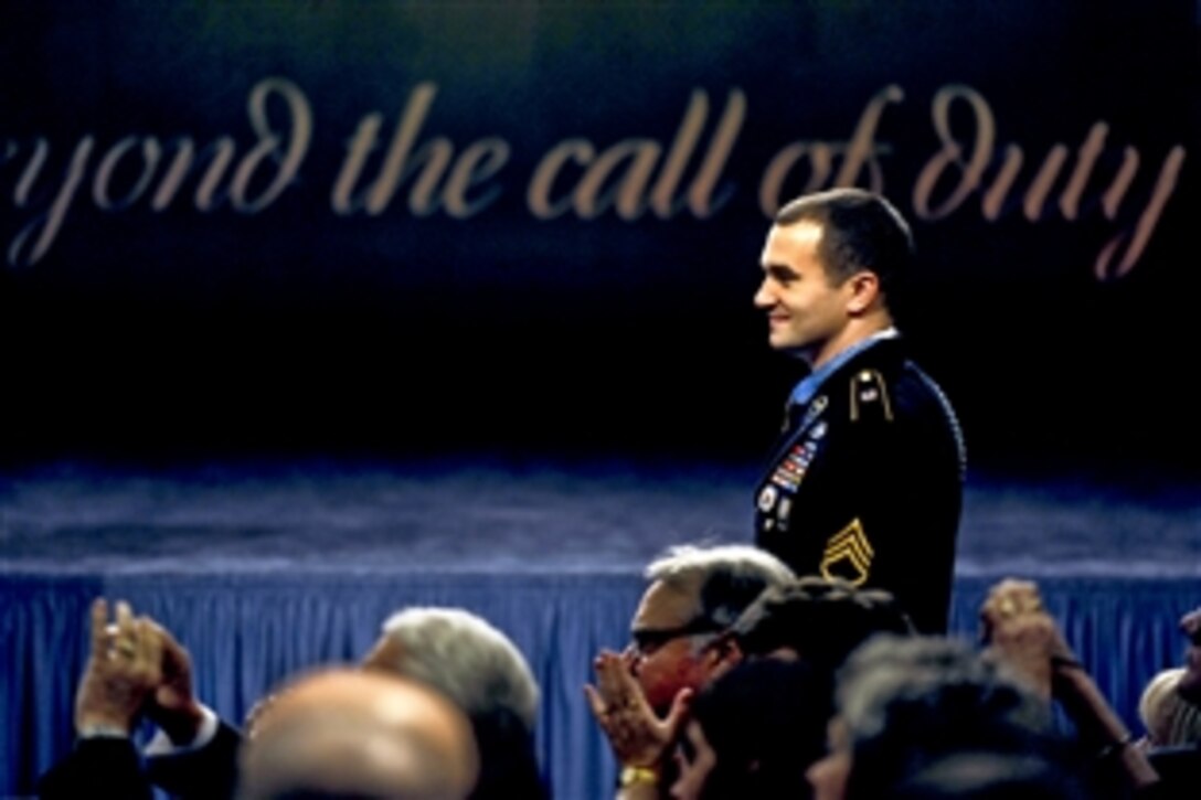 Medal of Honor recipient Army Staff Sgt. Salvatore Giunta looks over at his teamates from Battle Company, 2nd Battalion, 503rd Infantry Regiment, as they stand to be recognized during Giunta's induction ceremony into the Hall of Heroes at the Pentagon, Nov. 17, 2010. 