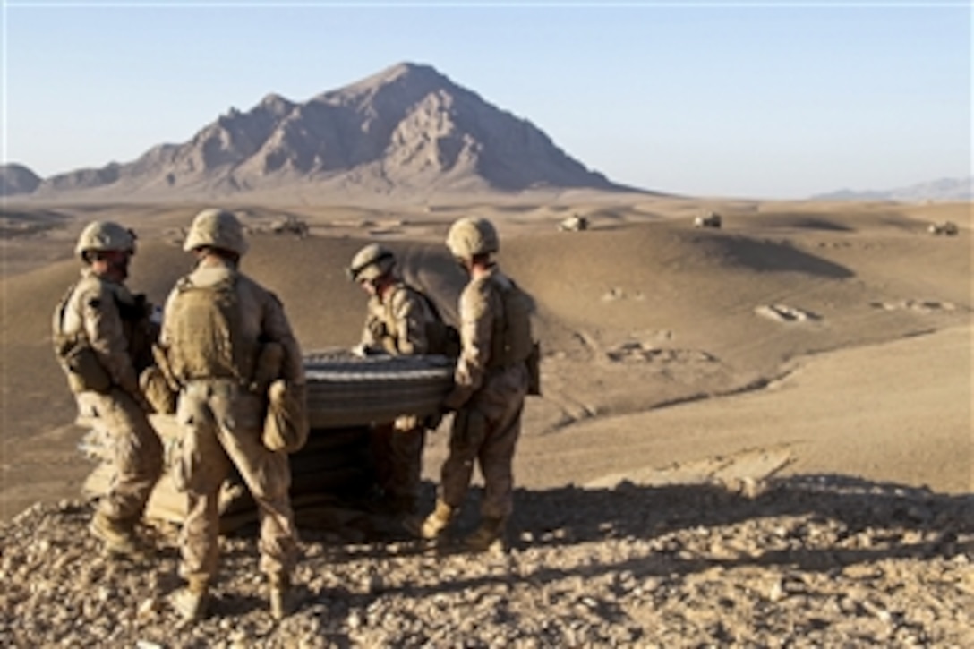 U.S. Marines serving as engineers move a stack of Hesco barriers at a new combat outpost in Musa Qal’eh, Afghanistan, Nov. 13, 2010. Building an elevated position at the top of a hill allows Afghan forces the ability to watch over the surrounding area. The engineers are assigned to the 1st Marine Division's 1st Combat Engineer Battalion.