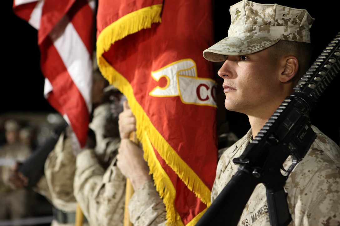 Pfc. Clint Sorg, a motor transport operator with Motor Transport Company B, Combat Logistics Battalion 3, 1st Marine Logistics Group (Forward), takes part in the color guard before a concert at Camp Dwyer, Afghanistan, Nov. 17. After the colors were presented, Ayla Brown, an American Idol semi-finalist, performed for servicemembers and civilians on the final stop of her Afghanistan concert tour.