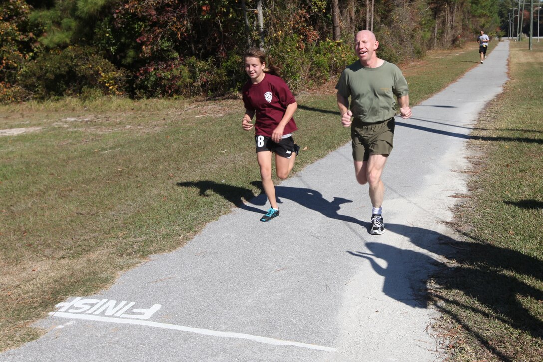 Participants Katie Cauble and her father near the finish line of the Turkey Trot 5K along Holcomb Boulevard, aboard Marine Corps Base Camp Lejeune, Nov. 18. The event was part of the Liberty Fun Run series sponsored by Semper Fit, which holds a 3-mile race before every holiday period.