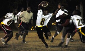Keith Coleman dodges the grasp of Lacorkney Bishop after intercepting the ball from the 628th Force Support Squadron during a flag football game on Joint Base Charleston, S.C., Nov. 16, 2010. After the interception, Coleman successfully evaded his opponents and ran nearly half the football field to score a touchdown for the 628th Logistics Readiness Squadron. (U.S. Air Force photo/Staff Sgt. Daniel Bowles)