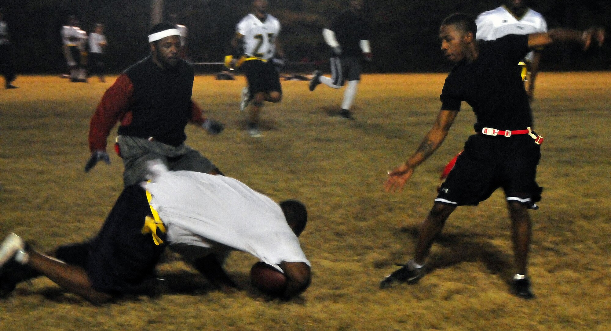 T. Wilkins takes a fall after being run down by Don Coleman, right, and Lacorkney Bishop, left, during the flag football game between the 628th Logistics Readiness Squadron and the 628th Force Support Squadron Nov. 16, 2010, on Joint Base Charleston, S.C. The game was tight between the teams, but ultimately a safety was a deciding factor for a win for the 628 LRS. Wilkins plays for the 628 LRS. Coleman and Bishop play for the 628 FSS. (U.S. Air Force photo/Staff Sgt. Daniel Bowles)
