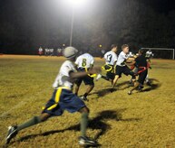 Players from the 628th Logistics Readiness Squadron rush the ball down the field, while blocking against members of the 628th Force Support Squadron during a football game on Joint Base Charleston, S.C., Nov. 16, 2010. During the game, the two teams battled for possession of the ball with multiple downs played at the goal lines, fending each other off to prevent a turnover. Losing yards to fouls but gaining them back with accurate passing, helped to land the 628 LRS the win. (U.S. Air Force photo/Staff Sgt. Daniel Bowles)
