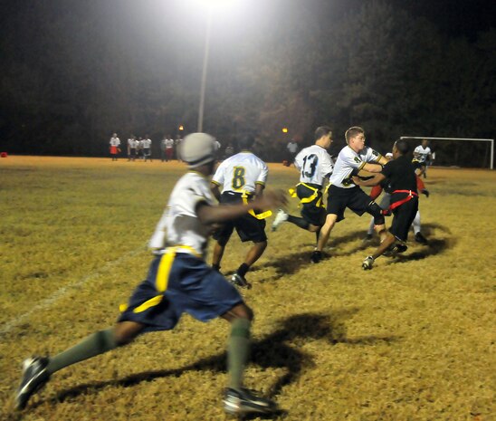 Players from the 628th Logistics Readiness Squadron rush the ball down the field, while blocking against members of the 628th Force Support Squadron during a football game on Joint Base Charleston, S.C., Nov. 16, 2010. During the game, the two teams battled for possession of the ball with multiple downs played at the goal lines, fending each other off to prevent a turnover. Losing yards to fouls but gaining them back with accurate passing, helped to land the 628 LRS the win. (U.S. Air Force photo/Staff Sgt. Daniel Bowles)