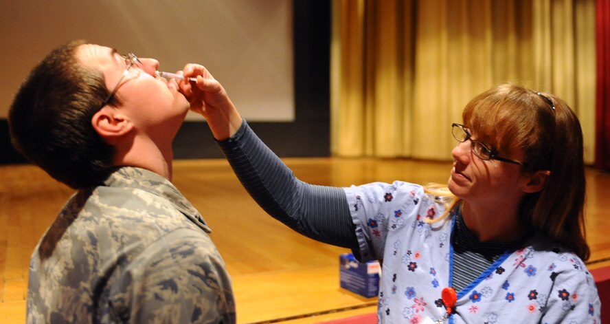 ELLSWORTH AFB, S.D. - Cathy Scolaro, 28th Medical Operations Squadron nurse, administers the flu mist vaccine to Senior Airman Kalin Anderson, Air Force Financial Service Center Air Force Reserve Command Auditor, Nov. 18. The flu mist vaccine is designed to encourage resistance to the illness. (U.S. Air Force photo/Senior Airman Kasey Close)